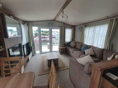 a living room with a sofa, coffee table, and large windows at Unity Holiday Resort - Holiday Accommodation 16507, Brean, Somerset, United Kingdom