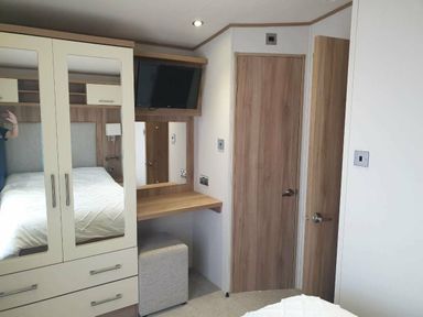 a bedroom with a bed, cabinet, mirror, and television at Unity Holiday Resort - Holiday Accommodation 16507, Brean, Somerset, United Kingdom