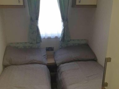 a bedroom with two single beds and a window at Unity Holiday Resort - Holiday Accommodation 16507, Brean, Somerset, United Kingdom