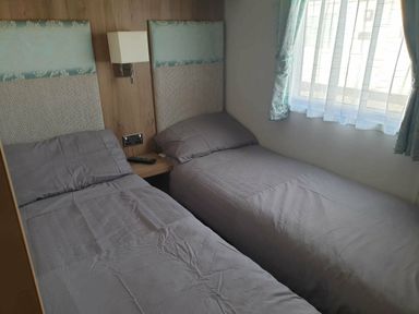 a bedroom with two single beds and a bedside table at Unity Holiday Resort - Holiday Accommodation 16507, Brean, Somerset, United Kingdom