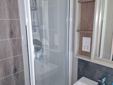 a bathroom featuring a shower with a glass door and a sink cabinet at Lakeland Leisure Park - Holiday Accommodation 16942 in Flookburgh
