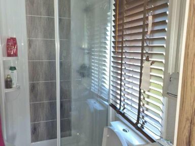 a bathroom with a shower stall and blinds at Lakeland Leisure Park - Holiday Accommodation 16942, Flookburgh