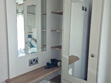 a dressing area with a mirror, shelves, and a small table at Lakeland Leisure Park - Holiday Accommodation 16942, Flookburgh