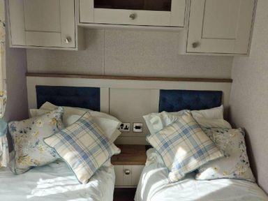 a bedroom with two twin beds and decorative pillows at Lakeland Leisure Park - Holiday Accommodation 16942 in Flookburgh