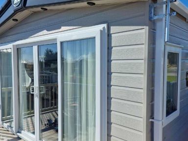 a corner view of a holiday home with large glass doors at Lakeland Leisure Park - Holiday Accommodation 16942, Flookburgh