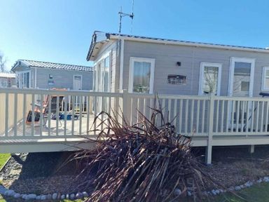 a holiday accommodation with a wooden deck and surrounding plants at Lakeland Leisure Park - Holiday Accommodation 16942 in Flookburgh