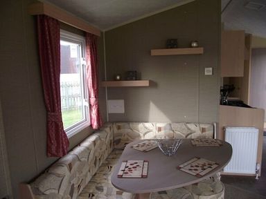 a dining area with a table and a bench seat at Butlins Minehead - Holiday Accommodation 1700 in Minehead
