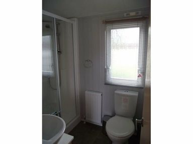 a bathroom with a shower, toilet, sink, and window at Butlins Minehead - Holiday Accommodation 1700 in Minehead