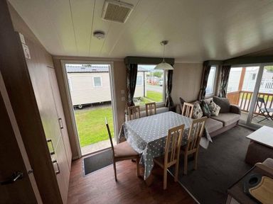 a dining area with a table and chairs in a mobile home at Hafan y Mor Haven - Holiday Accommodation 17436, Pwllheli