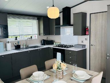 a kitchen with modern cabinetry and a dining table at Ashbourne Heights Holiday Park - Holiday Accommodation 18103 Ashbourne