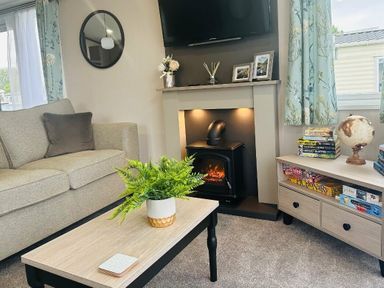 a living room with a sofa, coffee table, and electric fireplace at Ashbourne Heights Holiday Park - Holiday Accommodation 18103, Ashbourne