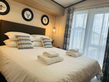 a bedroom with a bed, pillows, rolled towels, and framed animal pictures at Ashbourne Heights Holiday Park - Holiday Accommodation 18103, Ashbourne