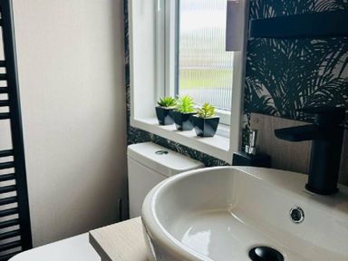 a bathroom featuring a sink, plants on the windowsill and a toilet at Ashbourne Heights Holiday Park - Holiday Accommodation 18103, Ashbourne