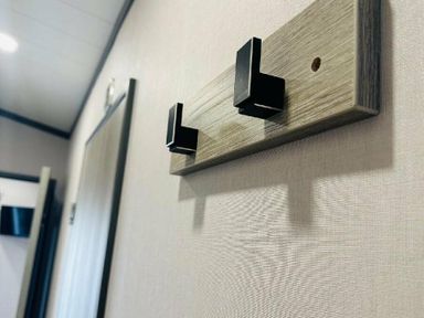 a wall hook with two black hooks on a wooden strip at Ashbourne Heights Holiday Park - Holiday Accommodation 18103 Ashbourne