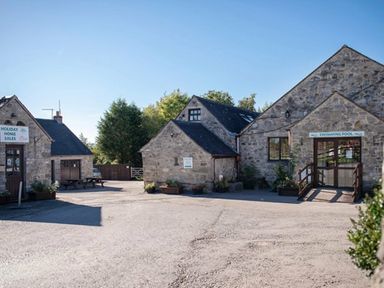 a stone building complex with a swimming pool sign and holiday home sales area at Ashbourne Heights Holiday Park - Holiday Accommodation 18103, Ashbourne