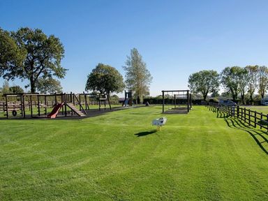 a playground with swings and slides on grass at Ashbourne Heights Holiday Park - Holiday Accommodation 18103 in Ashbourne
