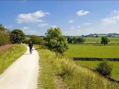 a cyclist on a path with greenery and fields at Ashbourne Heights Holiday Park - Holiday Accommodation 18103 in Ashbourne