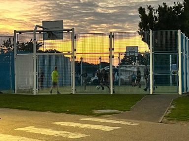 a fenced sports court with players engaged in soccer at Breydon Water Holiday Park - Holiday Accommodation 18490, Great Yarmouth