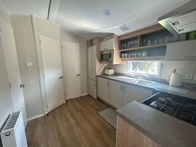 a kitchen with cabinets, a sink, and an oven at Breydon Water Holiday Park - Holiday Accommodation 18490 in Great Yarmouth