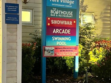 a sign displaying entertainment options including a bar, restaurant, arcade, and swimming pool at Pure Village in Great Yarmouth