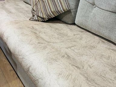 a sofa with textured upholstery and a decorative pillow at Breydon Water Holiday Park - Holiday Accommodation 18490, Great Yarmouth