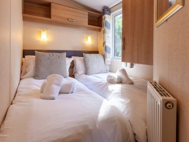 a bedroom with two beds and towels at Kelling Heath Holiday Park - Holiday Accommodation 18663, Holt