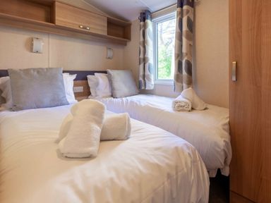 a bedroom with two single beds and a window at Kelling Heath Holiday Park - Holiday Accommodation 18663 in Holt