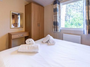 a bedroom with a bed and towels on it at Kelling Heath Holiday Park - Holiday Accommodation 18663, Holt