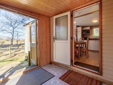 an entrance area with an open door leading to a dining space at Kelling Heath Holiday Park - Holiday Accommodation 18663, Holt