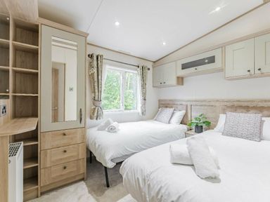 a bedroom with two beds and a wardrobe at Kelling Heath Holiday Park - Holiday Accommodation 18664 in Holt