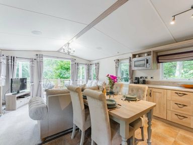 an open plan living and dining area with a kitchen and a seating arrangement at Kelling Heath Holiday Park - Holiday Accommodation 18664, Holt