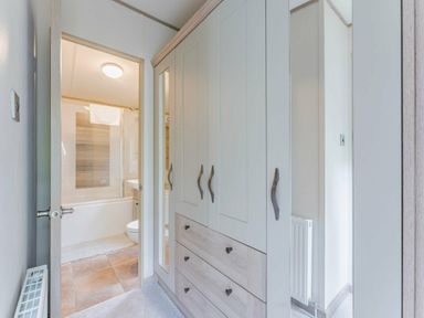 a bathroom with a shower and a closet with drawers at Kelling Heath Holiday Park - Holiday Accommodation 18664 in Holt