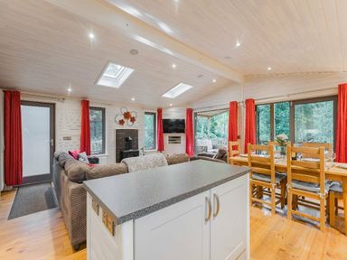 a living room with large windows and a dining area at Kelling Heath Holiday Park - Holiday Accommodation 18691, Holt