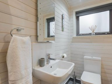 a bathroom with a sink, toilet, and mirror at Kelling Heath Holiday Park - Holiday Accommodation 18691, Holt