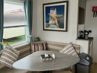 A dining area with a table and cushions at Whitehouse Leisure Park - Holiday Accommodation 19055, Towyn, Abergele