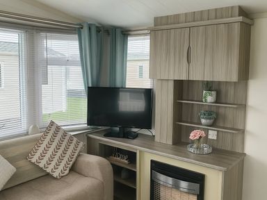A living room with a sofa, tv, and shelves at Whitehouse Leisure Park - Holiday Accommodation 19055 Towyn, Abergele