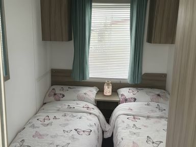 A bedroom with two beds and a bedside table at Whitehouse Leisure Park - Holiday Accommodation 19055, Towyn, Abergele