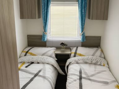 A bedroom with two single beds and a window at Whitehouse Leisure Park - Holiday Accommodation 19055, Towyn, Abergele
