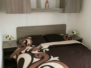 A bedroom with a bed and nightstand at Whitehouse Leisure Park - Holiday Accommodation 19055, Towyn, Abergele