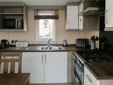 A kitchen with a sink and a stove at Whitehouse Leisure Park - Holiday Accommodation 19057, Towyn, Abergele