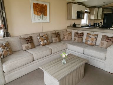 A living room with a sofa, coffee table, and wall art at Whitehouse Leisure Park - Holiday Accommodation 19057, Towyn, Abergele
