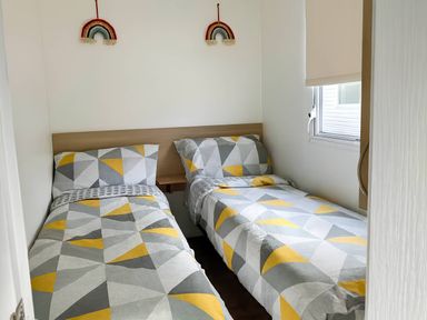 A bedroom with two single beds and a window at Golden Gate Holiday Centre - Holiday Accommodation 19058 Towyn