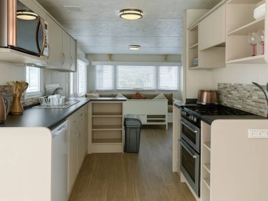 A kitchen with appliances and seating area at Golden Gate Holiday Centre - Holiday Accommodation 19058, Towyn