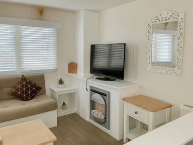 A living room with a sofa and television at Golden Gate Holiday Centre - Holiday Accommodation 19058, Towyn