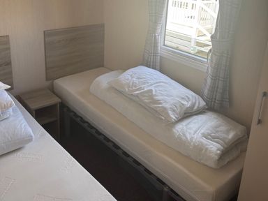 A bedroom with a bed and nightstand at Southview Holiday Park - Holiday Accommodation 19123 in Skegness