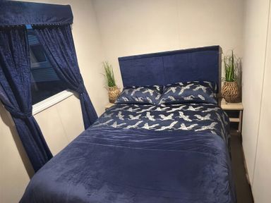 A bedroom with a bed and curtains at Presthaven Beach Resort - Holiday Accommodation 19166, Prestatyn