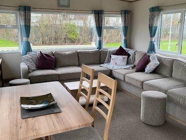 a living room with a sectional sofa and dining table at Butlins Skegness - Holiday Accommodation 19332 in Skegness
