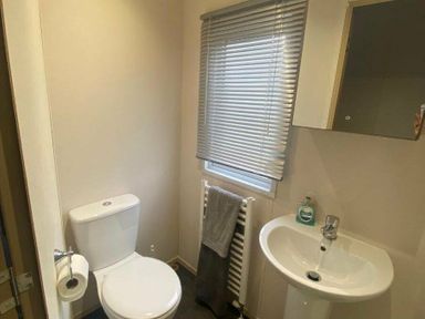 a bathroom with a toilet, sink, and window at Butlins Skegness - Holiday Accommodation 19332 in Skegness