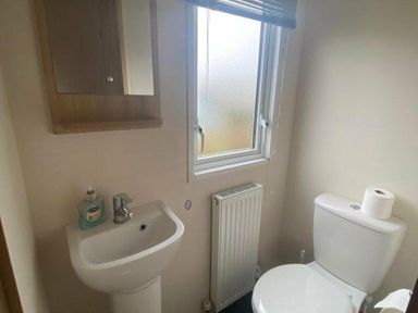 a bathroom with a sink, toilet, window, and mirror at Butlins Skegness - Holiday Accommodation 19332 in Skegness