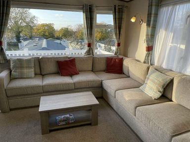 a corner seating area with cushions and a coffee table at Rockley Park - Holiday Accommodation 19386, Poole